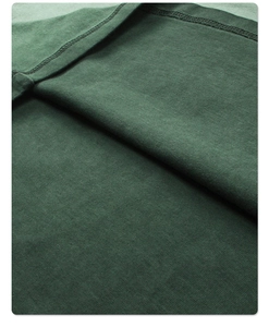 Macro shot of forest green heavy cotton knit fabric with durable double-stitch seam details