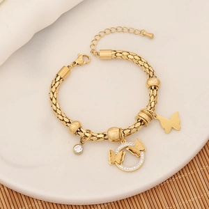 Detailed shot of golden charm bracelet with butterfly pendants and sparkling crystals