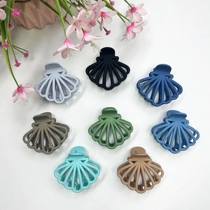 Eight matte shell-shaped hair claws in various colors arranged in a circle on white background