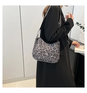 Side view of a vintage leopard print crossbody bag with adjustable wide strap on model