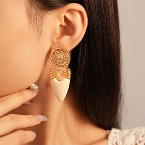 Boucles d'oreilles vintage avec nœud, cœur et strass portées par un mannequin
