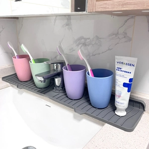 Gray silicone kitchen sink splash guard with anti-slip ridges and colorful cups