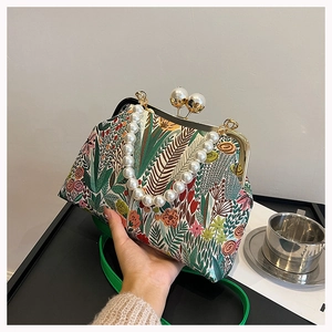 Detail der Blumenstickerei und des Perlengriffs an einer Vintage-China-Handtasche