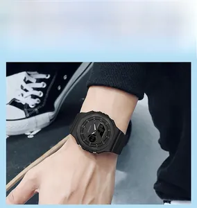 Street style close-up of a black octagonal dual display sports watch worn outdoors