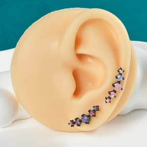 Detail showing five synthetic opals set in black stainless steel on an ear model