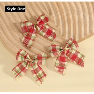Detail of red and green plaid Christmas bows with gold ties on a wooden tray