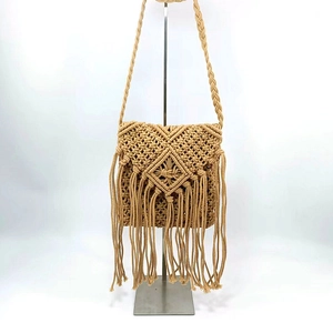 Close-up of bohemian macrame crossbody bag with woven diamond patterns and fringe details