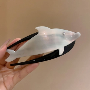 Detail view of pearlescent acrylic dolphin hair claw with rhinestone eye and AJ1013 stamp