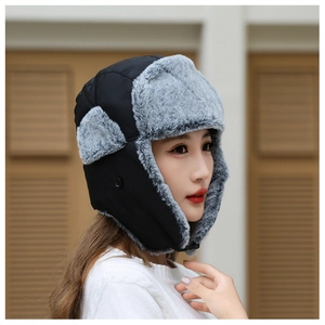 Detail view of winter trapper hat with black windproof fabric and grey faux fur lining