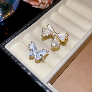 Detail of 14k gold plated bow and flower rings with zircons on velvet lining