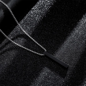 Titanium steel necklace with black columnar pendant on a dark glitter background