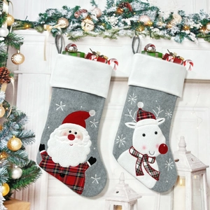 Detail of knitted Christmas stockings with Santa and reindeer motifs hanging on a fireplace