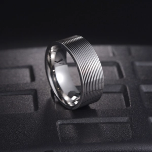Macro view of 8mm silver titanium steel ring with textured multi-layer grooved design