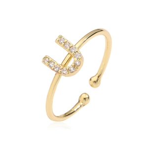 Detail of gold open ring featuring letter U inlaid with sparkling zircon stones