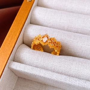 Detailed close-up of a matte gold flower ring with marquise-cut crystal in a jewelry box