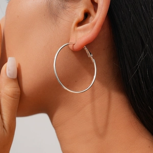 On-ear detail of minimalist silver pearl hoop earrings showing elegant metallic texture