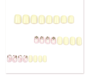 Detail of short square press-on nails featuring white daisies and pastel yellow finish