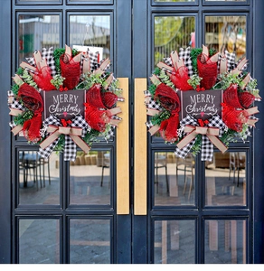 Detail of Christmas wreath with red ribbons, berries and Merry Christmas wooden sign