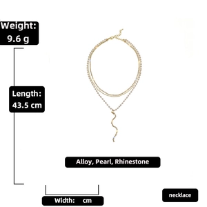 Detail of gold multi-layer necklace featuring pearls, rhinestones, and fringe pendant