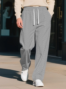 Detailaufnahme der grauen Herren-Jogginghose mit Kordelzug und Jacquard-Zopfstrickmuster