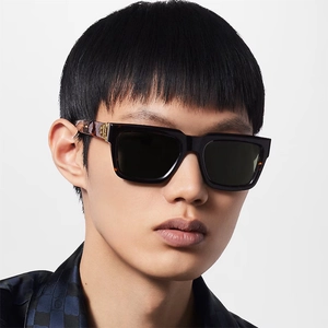 Close-up of square sunglasses featuring black frames and tortoise pattern temples with gold logo