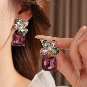 Detailed view of vintage flower earrings with multicolor gems and purple square pendant
