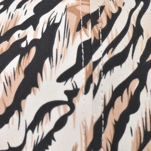 Detail der Baseballkappe mit Tigerprint, Doppelnaht und Textur des hochwertigen Stoffes