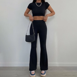 Dettaglio del tessuto a costine nere del completo crop top aderente e pantaloni a vita alta