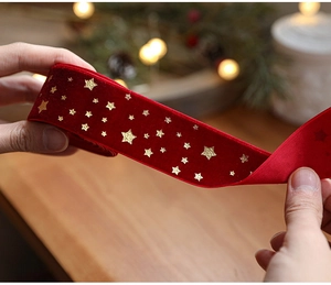 Close-up of red velvet Christmas ribbon with gold star foil print for tree decoration