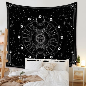 Detail of bohemian black sun and moon phase tapestry hanging above a bedroom bed