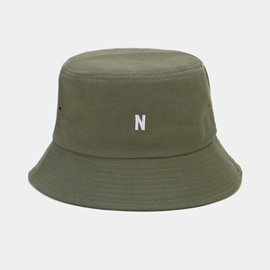 Détail d'un chapeau bob en toile vert armée avec broderie blanche 3D lettre N sur le devant