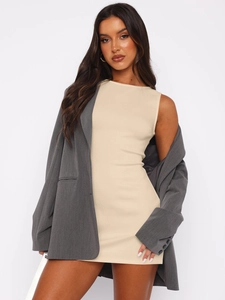 Détail de la robe sans manches abricot avec un blazer oversize gris foncé élégant