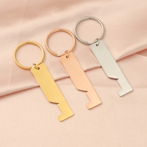Three house-shaped stainless steel keychains in gold, rose gold and silver on silk