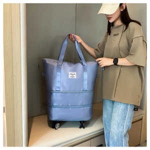 Close-up of grey-blue expandable travel bag with 360 wheels and double layer base