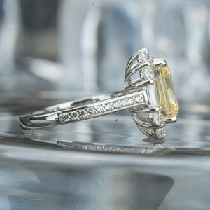 Macro side view of emerald-cut yellow zircon ring with micro-pave diamond setting