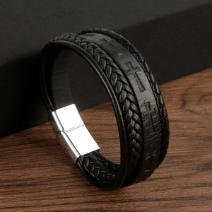 Macro shot of men's black leather braided bracelet with cross-embossed magnetic clasp