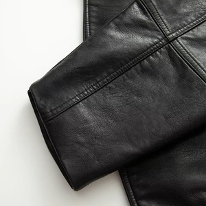 Close-up of black leather jacket detailing neat double stitching and natural grain texture