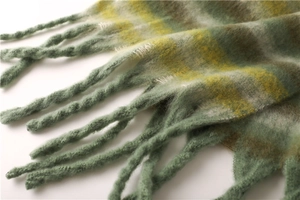 Close-up of soft green and yellow striped cashmere scarf with long fringe details