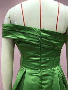 Vue détaillée du dos de la robe en satin vert avec fermeture éclair et plissages
