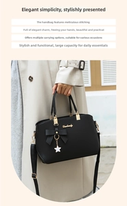 Detail of black pebbled leather handbag with bow decor, flower charm and gold hardware
