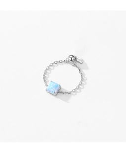 Macro shot of S925 sterling silver chain ring with square blue opal and logo tag