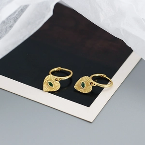 Detail showing vintage gold heart earrings with green stone and sunburst texture