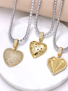 Detailed macro view of three gold heart pendants on sparkling cubic zirconia tennis chains