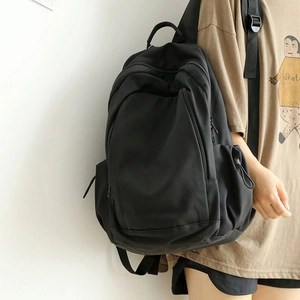 Minimalist large capacity black backpack for students on neutral white background