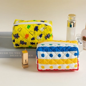 Macro view of quilted cotton cosmetic bags featuring floral and striped patterns