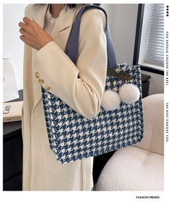 Blue houndstooth canvas tote bag detail with fuzzy white pompom and decorative pendant