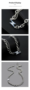 Detail of double-layer chain necklace with blue enamel lightning pendant and zircon