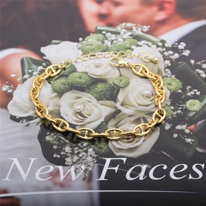 Gold coffee bean link bracelet with lobster clasp on a fashion magazine background