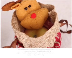 Close-up of a Christmas drawstring treat bag with a plush reindeer doll and an apple