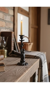 Détail d'un bougeoir rétro en fonte avec texture en relief sur une table en bois rustique